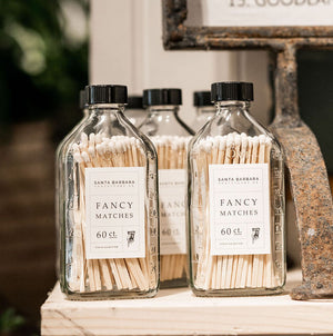 Several rows of glass bottles on a shelf labeled 